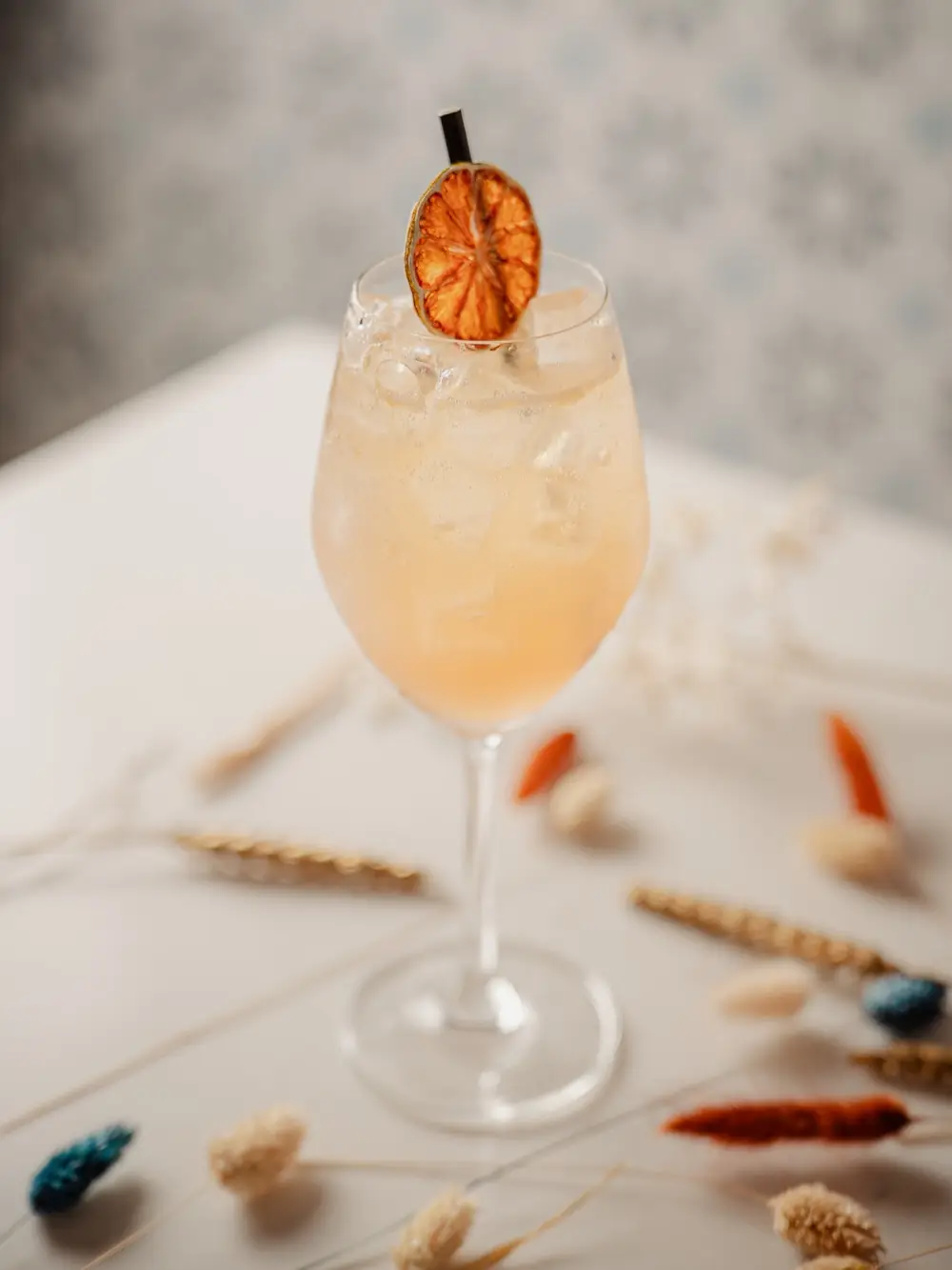 Agua de Valencia in a wine glass with a dried orange slice