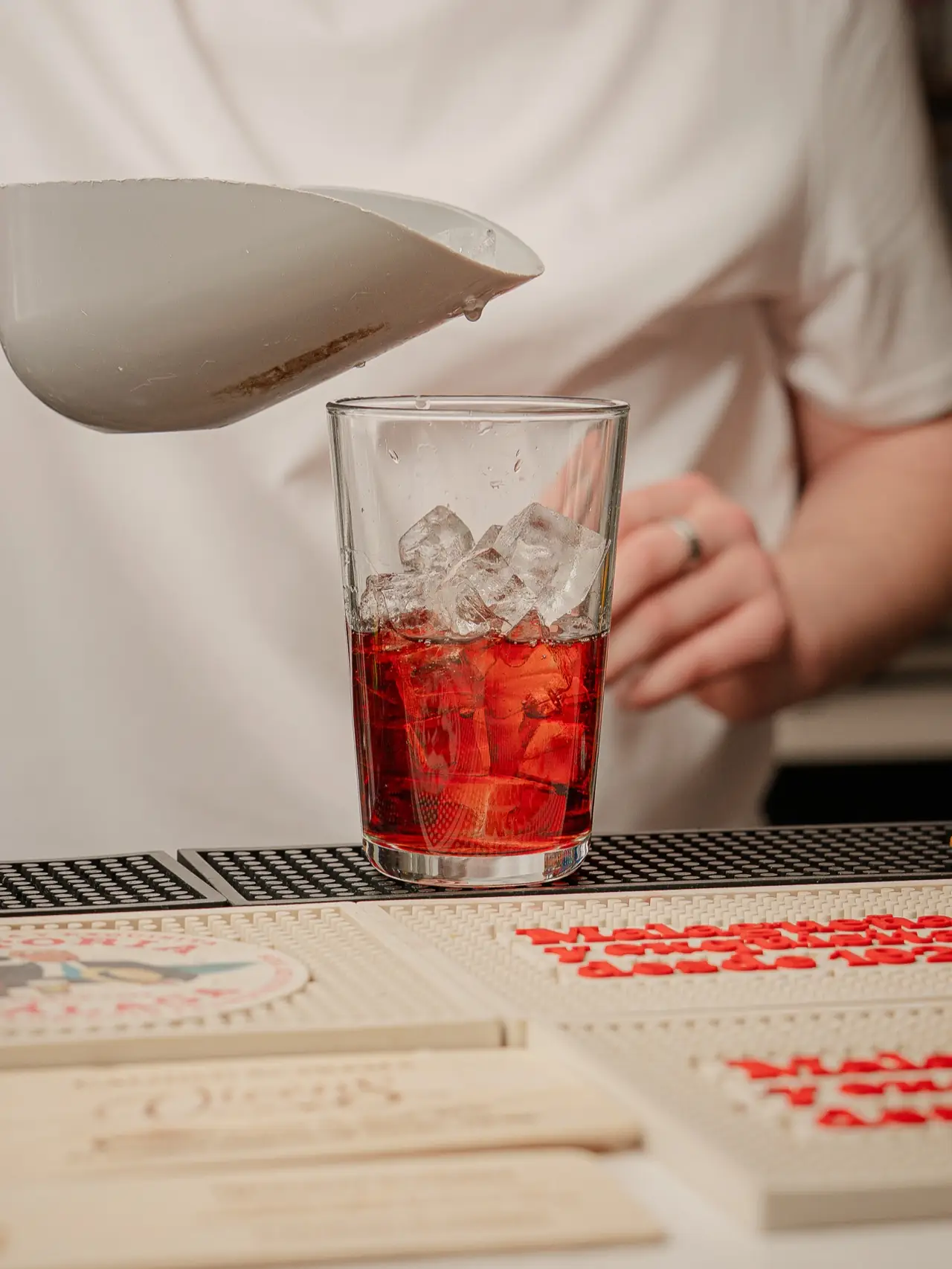 The bartender making cocktails in front of the blue bar