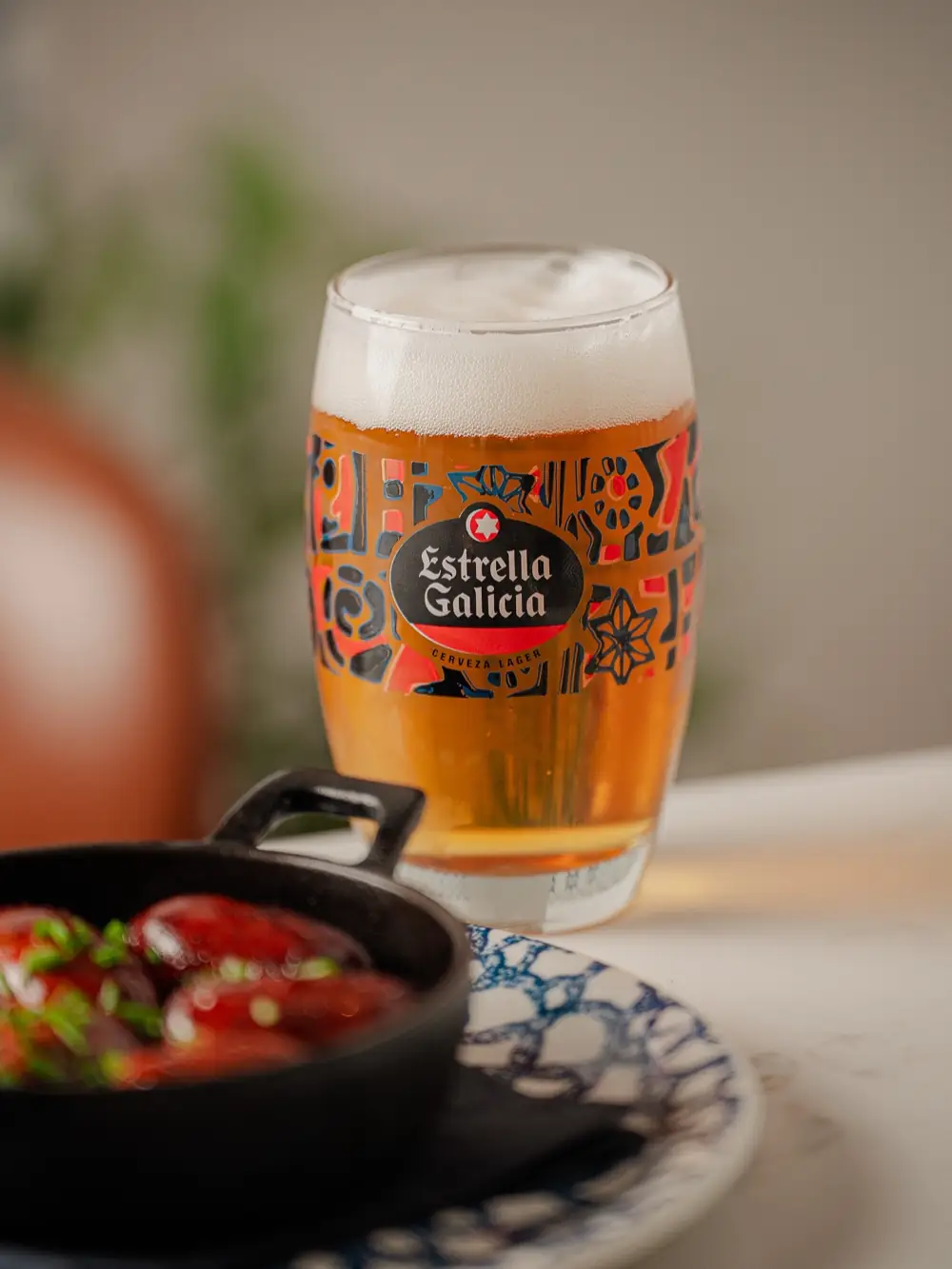 Chorizo cooked in red wine in a cazuela, with a cold Estrella Galicia