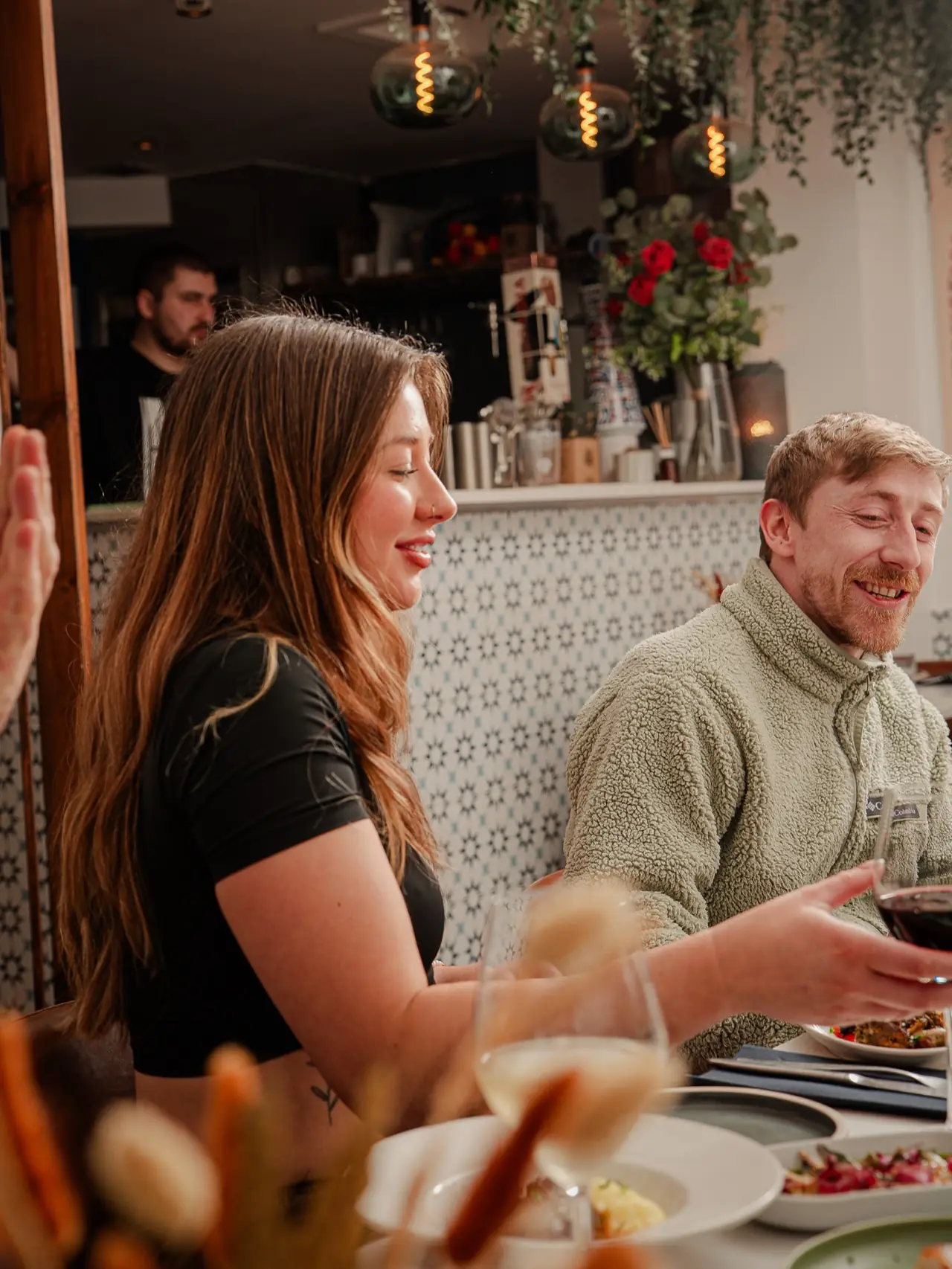 Friends laughing over wine and a table of tapas
