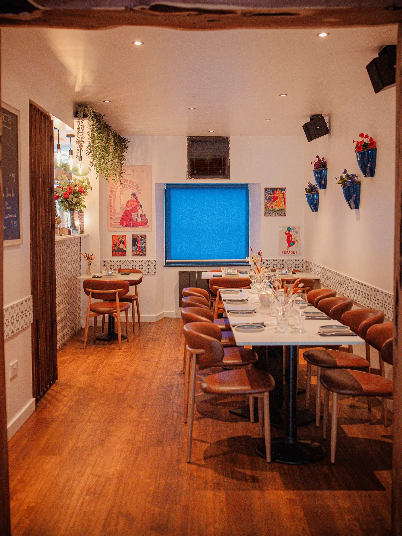 The long room at tapastres, tables laid down one side under warm pendant lights